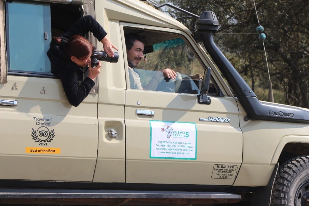 Guests photographing wildlife from a Kubwa Five Safaris Land Cruiser